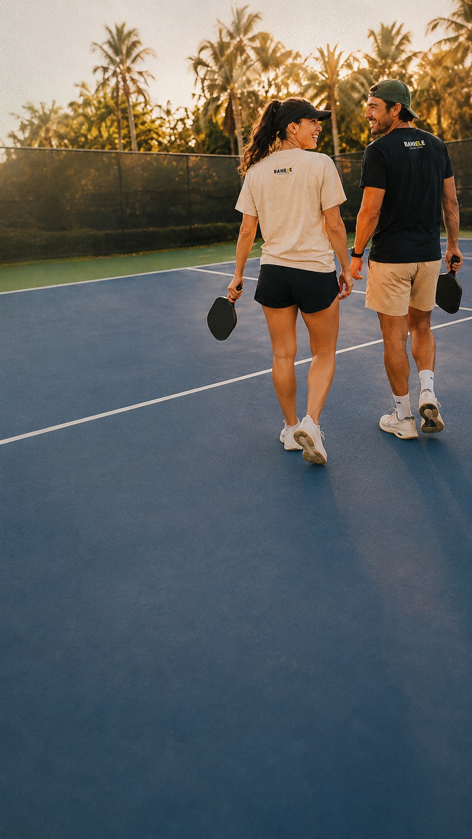 Two players walking off a pickleball court in Bahele pickleball tees